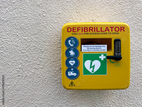 Tableau sur toile First aid heart debribrillator on a wall in a park in Cheltenham, UK