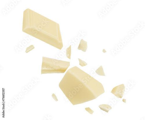  Levitating white milk chocolate chunks isolated on white background. Flying Chocolate pieces explosion, shavings and cocoa crumbs Top view. Flat lay.