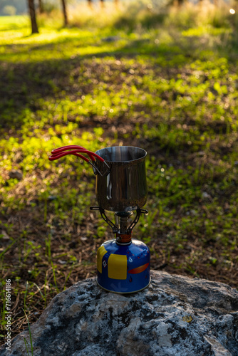 Portable gas stove heating a coffee pot on a rock in Beit Shemen forest, Jerusalem, Israel