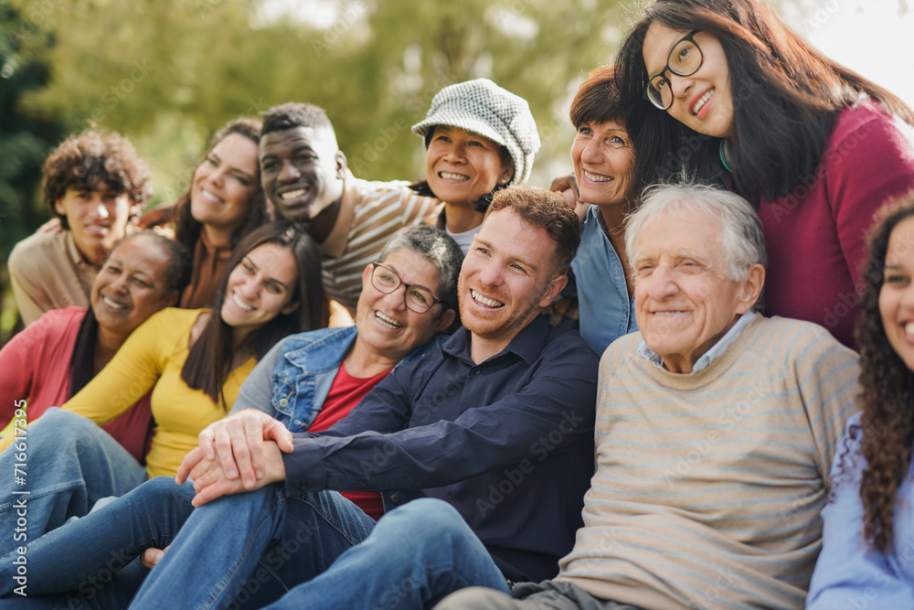 Group of multiracial people with different ages having fun together at city park - Community and social gathering concept Group of multiracial people with different ages having fun together at city park - Community and social gathering concept