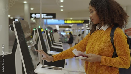 Black women with short, curly hair in airport check-in via automatic machines by herself in the airport to travel or study abroad.