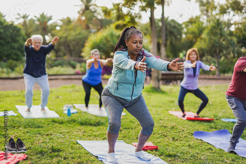 Fit multiracial senior people doing yoga exercise at city park - Mental health concept photo