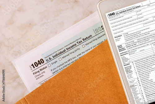 Filing online on digital tablet with individual income tax form 1040 is prepared by accounting office during tax season photo