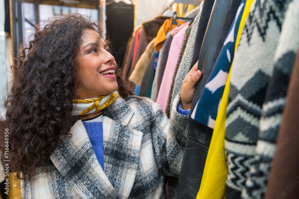 Woman looking clothes in a vintage second hand store