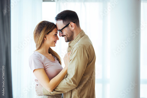Two people in big love, hugging each other. Happy couple in their new home. Young couple hugging indoors. Young couple sharing a romantic moment.