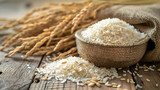 Long grain rice in a wooden bowl. White rice spills out on the wooden table. Food photo, light natural colors. High quality