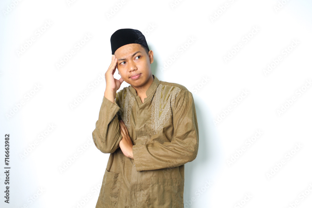 thoughtful asian muslim man thinking seriously with touching his head wearing koko clothes isolated on white background thoughtful asian muslim man thinking seriously with touching his head wearing koko clothes isolated on white background