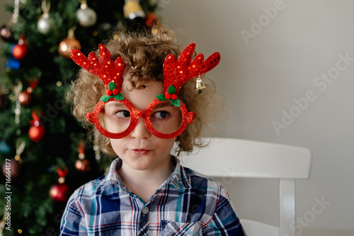 Happy, young boy wearing novelty glasses celebrating Christmas at home in Australia photo