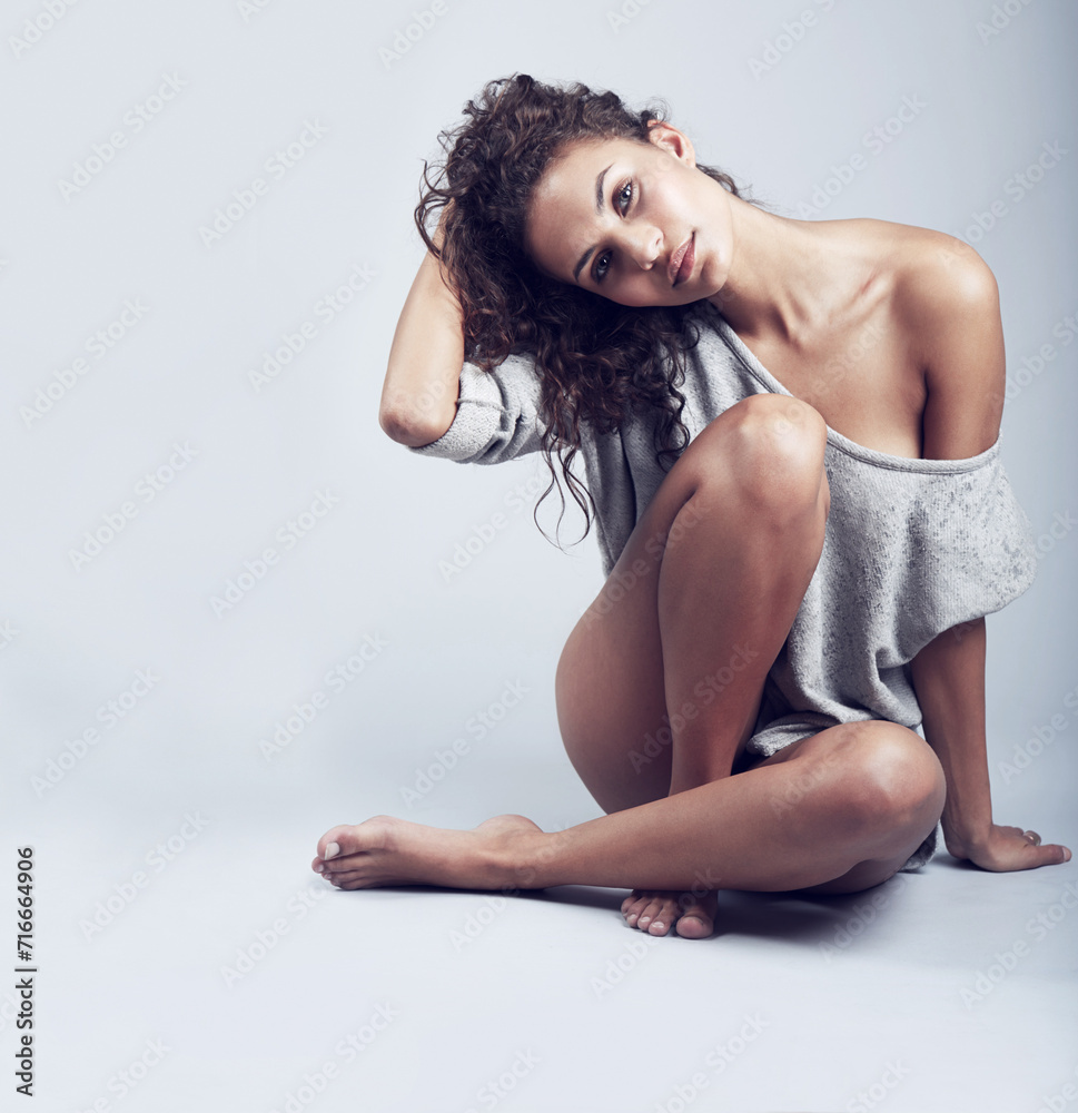 Obraz premium Hair care, beauty and portrait of woman in studio sitting on floor with confidence on gray background mockup. Casual, cosmetics and model with natural makeup or minimal aesthetic for hairstyle