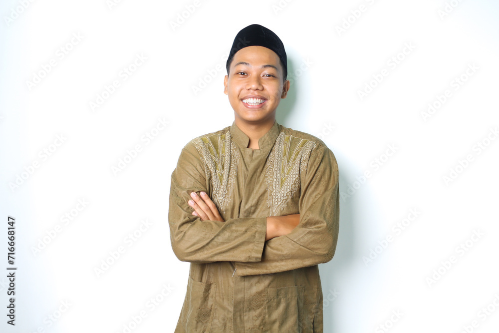 asian muslim man smiling with folded arms and looking at camera wearing koko clothes on eid al fitr celebration isolated on white background asian muslim man smiling with folded arms and looking at camera wearing koko clothes on eid al fitr celebration isolated on white background