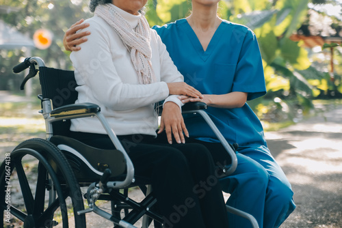 A nurse take care a senior male on wheelchair in his garden at home