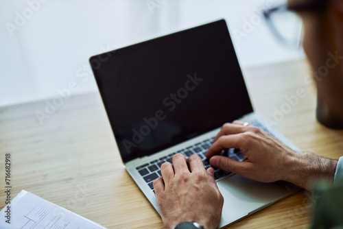 Close-up on man's hands using a laptop for modern work and typing on its keyboard.