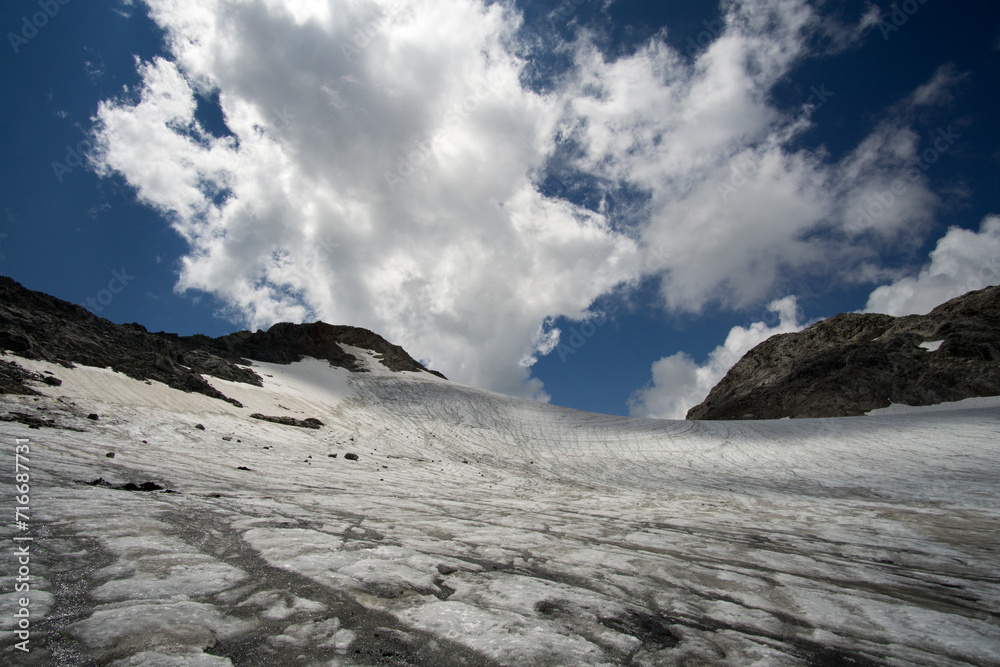 Expansive view of a snow-covered glacier under a dramatic cloudy sky