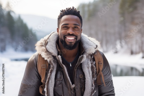 Portrait of a blissful afro-american man in his 30s wearing a rugged jean vest against a backdrop of a frozen winter lake. AI Generation