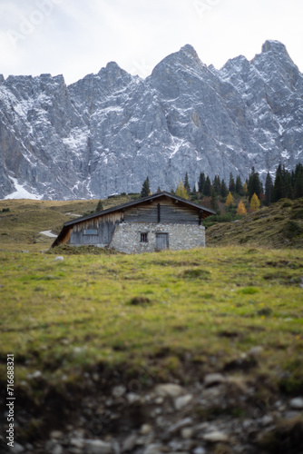 A tranquil mountain cabin nestled against a backdrop of majestic, snow-capped peaks.