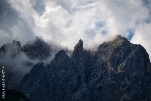 Teleaufnahme eines düsteren Bergmassivs mit tief hängenden Wolken am Gipfel