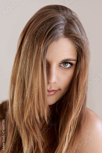 Portrait, straight hair and beauty of woman in salon treatment for keratin care. Serious face, hairstyle shine and young model in makeup cosmetics at hairdresser isolated on a gray studio background