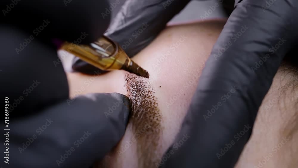 Shooting macro application of pigment into the skin of eyebrows at the procedure of permanent eyebrow makeup. Permanent makeup procedure, performing PMU of eyebrows