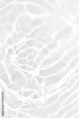 White water with ripples on the surface. Defocus blurred transparent white colored clear calm water surface texture with splashes and bubbles. Water waves with shining pattern texture background.