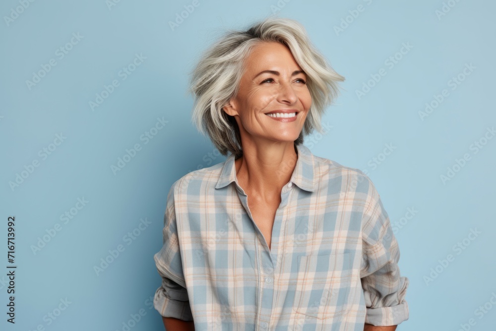 Portrait of a satisfied woman in her 50s dressed in a relaxed flannel shirt against a pastel blue background. AI Generation Portrait of a satisfied woman in her 50s dressed in a relaxed flannel shirt against a pastel blue background. AI Generation