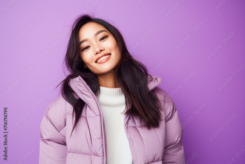 Portrait of a joyful asian woman in her 20s sporting a quilted insulated jacket against a pastel purple background. AI Generation Portrait of a joyful asian woman in her 20s sporting a quilted insulated jacket against a pastel purple background. AI Generation