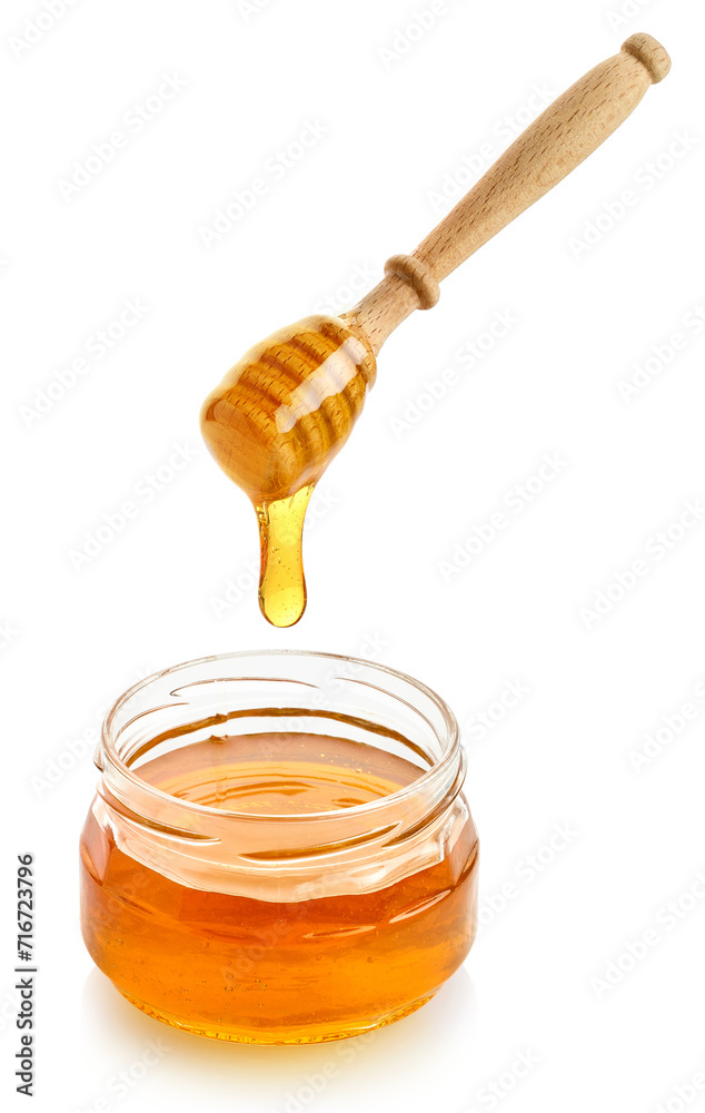 Glass jar full of honey and wooden dipper on white background Glass jar full of honey and wooden dipper on white background