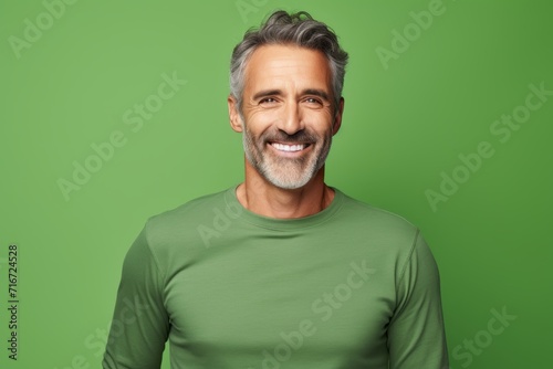 Portrait of a cheerful man in his 50s showing off a lightweight base layer against a soft green background. AI Generation © CogniLens