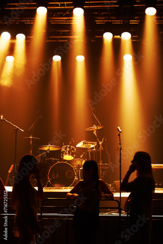 Silhouette, band and playing at stage for concert, spotlight and instruments for music festival. Musician, singing and sound entertainment by event equipment by technology and audio performance