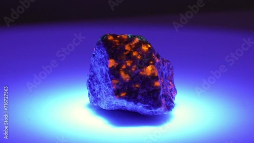 natural yooperlite gem stone in ultraviolet light photo