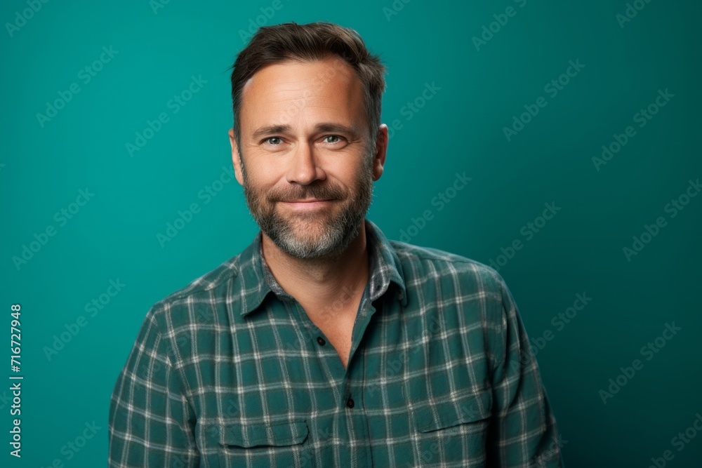Portrait of a tender man in his 40s wearing a comfy flannel shirt against a soft teal background. AI Generation Portrait of a tender man in his 40s wearing a comfy flannel shirt against a soft teal background. AI Generation