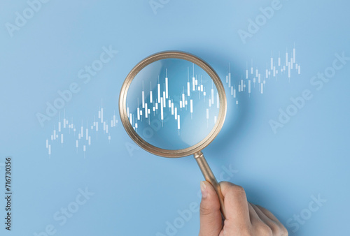 Magnifier focus on stock or forex market graph trading. Discovery trend grow up gain and profits. Analysis technical grap investment economic earning income concept.