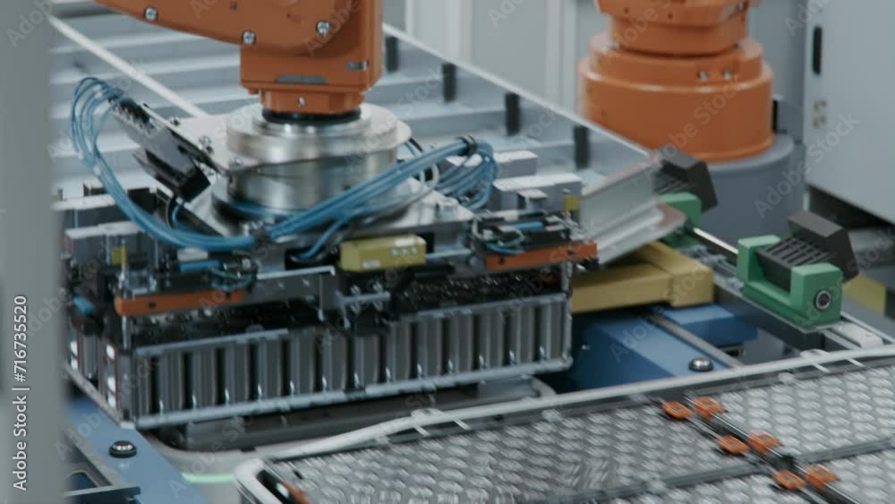 EV Battery Pack for Automotive Industry Assembly. Robot Arm Installing Battery Module into the Frame. Electric Car Smart Factory. Battery Manufacturing Line. Automated Production Line.