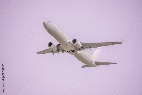 Bilde på lerret A passenger plane ascending in a homogeneous light purple sky
