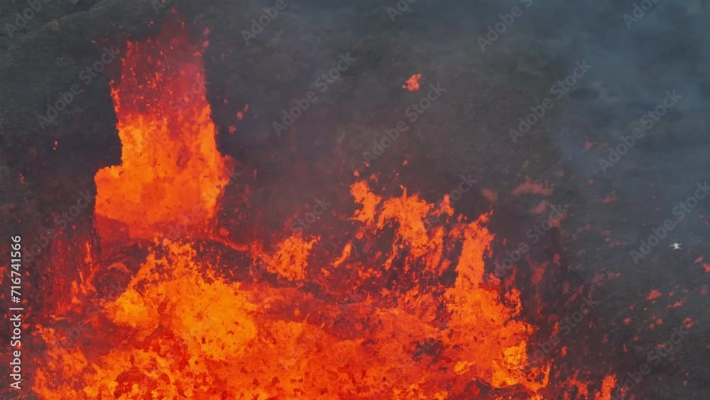 Aerial drone fly view over active volcanic crater eruption. Hot lava and magma coming out of the crater. Tourist attraction in Iceland Litli-Hrútur eruption 2023. Beautiful and dangerous disaster.