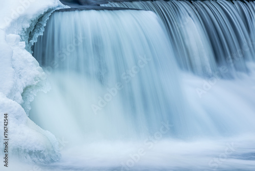 Winter  Rabbit River Cascade framed by ice and captured with motion blur  Michigan  USA