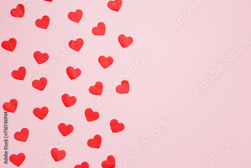 Paper hearts on a pink background for Valentine's Day, happy anniversary. Top view. Copy space