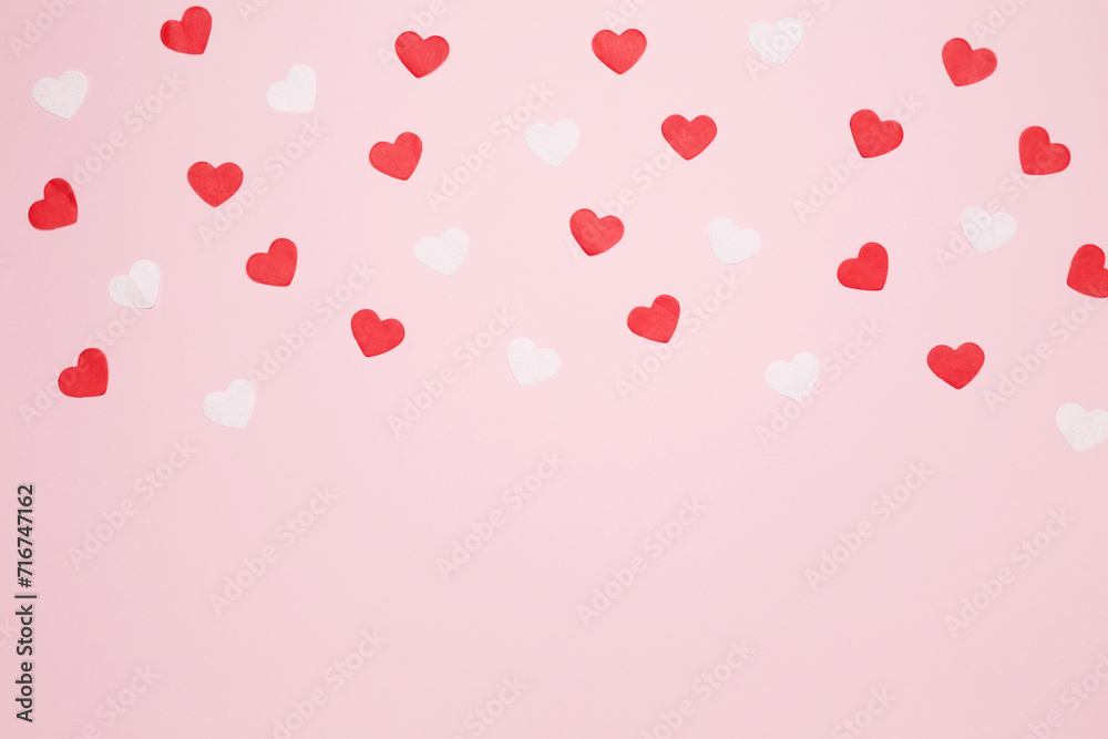 Paper hearts on a pink background for Valentine's Day, happy anniversary. Top view, copy space