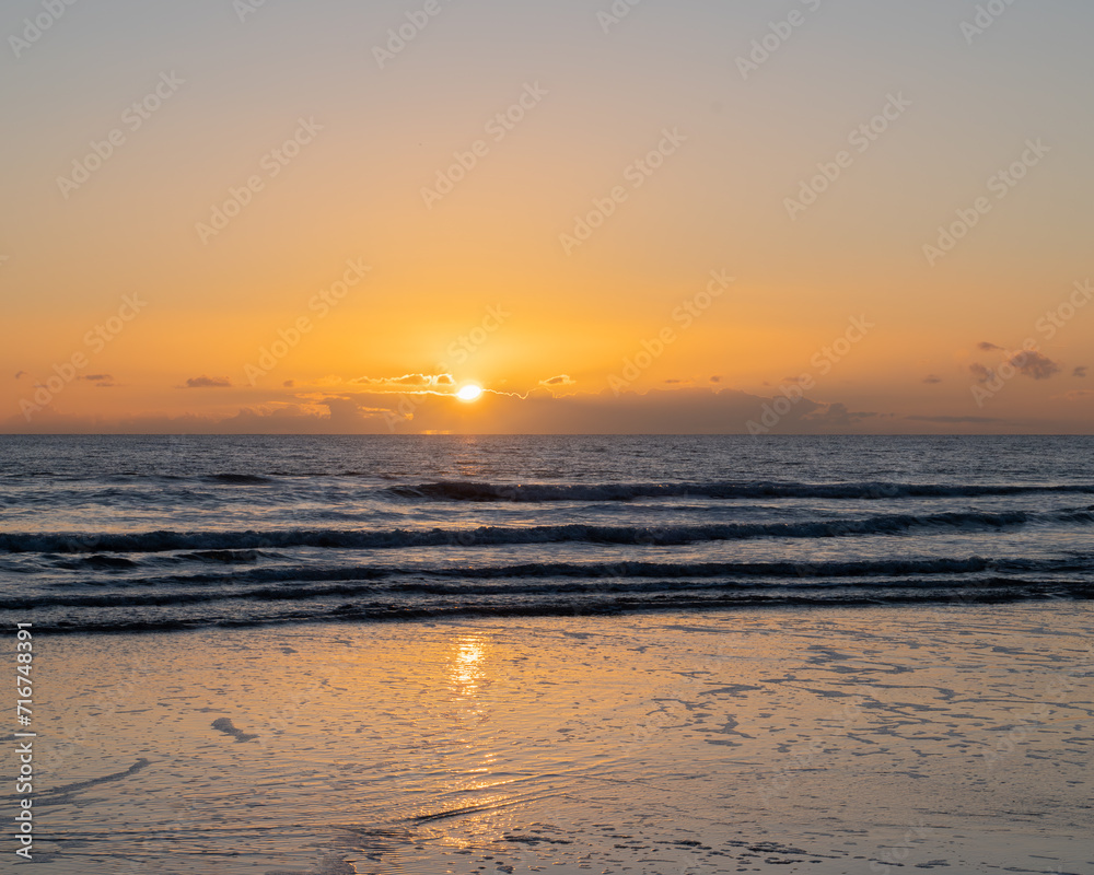Mesmerizing beach sunset with vibrant colors, tranquil waves, and coastal beauty, ideal for relaxation, travel, golden skies