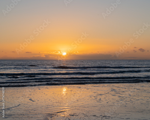 Mesmerizing beach sunset with vibrant colors  tranquil waves  and coastal beauty  ideal for relaxation  travel  golden skies