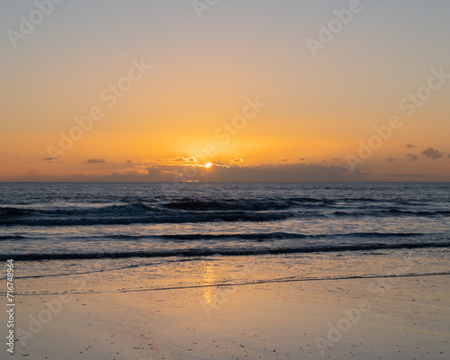 Mesmerizing beach sunset with vibrant colors  tranquil waves  and coastal beauty  ideal for relaxation  travel  golden skies
