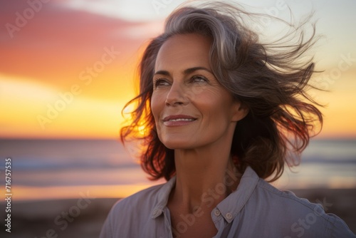 Portrait of a tender woman in her 50s dressed in a casual t-shirt against a vibrant beach sunset background. AI Generation © CogniLens