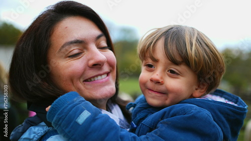 Son Kissing Mother on Cheek, Beautiful Family Moment. Child hugging mom in lifestyle scene, authentic loving relationship