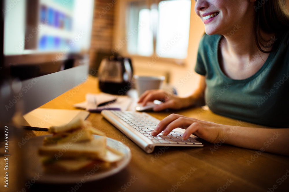 Woman working from home with coffee and smartphone