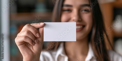 A young woman holding a blank business card