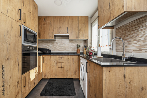 A kitchen with chestnut wood cabinets,
