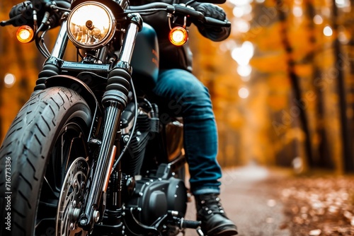 A motorcyclist on a cruiser bike surrounded by picturesque autumn foliage on a peaceful forest road. photo