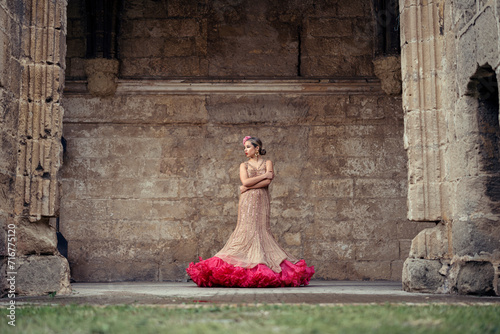 Chica joven rubia con traje flamenco posando en antiguo monasterio