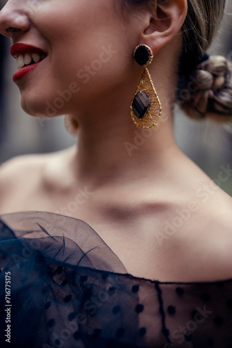 Foto detalle de pendientes de una chica rubia en traje de flamenco