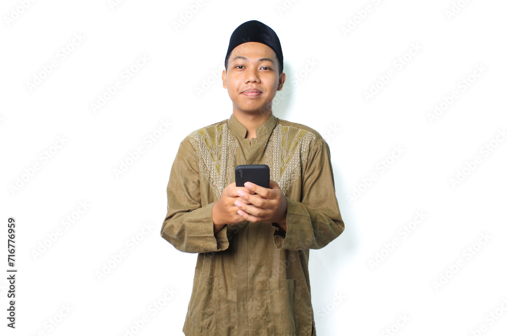pleased asian muslim man read a message using mobile phone isolated on white background pleased asian muslim man read a message using mobile phone isolated on white background