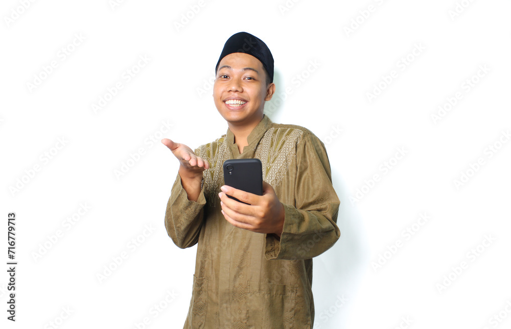 excited asian muslim man presenting application using mobile phone isolated on white background excited asian muslim man presenting application using mobile phone isolated on white background